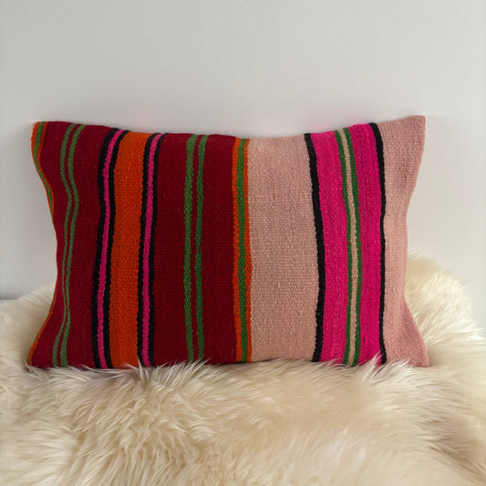 Striped Moroccan pillow with pink, green, and red colours on a white background